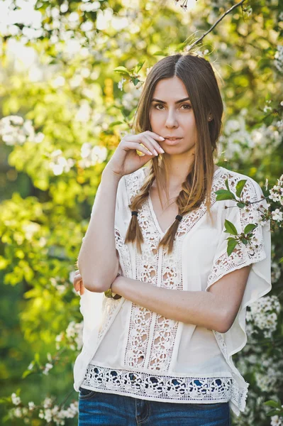Fehér blúz lány áll a háttérben egy virágzó Ap — Stock Fotó