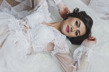 Beyaz elbiseli kız beyaz kumaşlar arasında 6368 yatıyor..