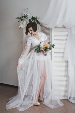 Yarı saydam bir sabahlık kız b arka plan üzerinde duruyor