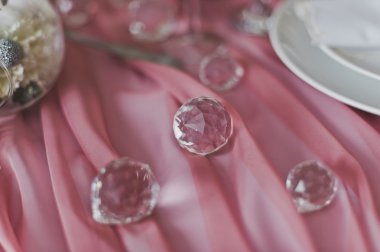 Pembe kumaş üzerine cam toplar ve w boş davet vardır