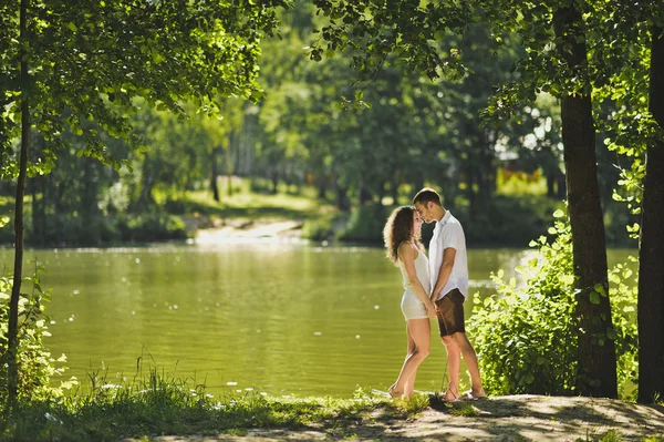 Jeune garçon et fille debout sur la rive du lac vert 6302 . — Photo