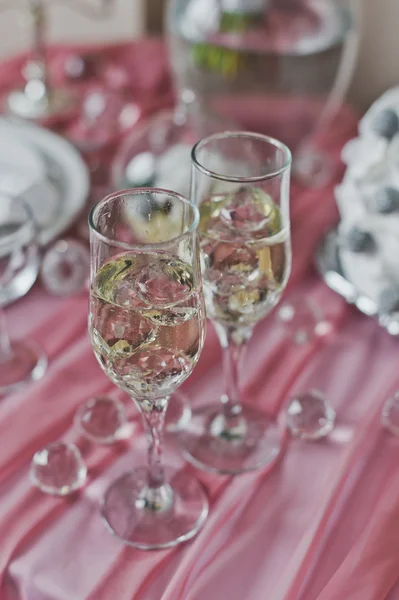 Champagneglas är på en rosa, inredda tabellen 6447. — Stockfoto