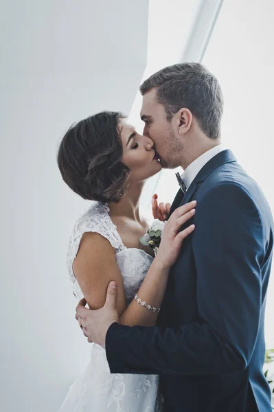 Um beijo suave dos recém-casados no fundo de Windo brilhante — Fotografia de Stock