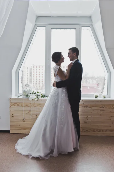 Retrato dos recém-casados abraçando contra uma grande janela 6456 . — Fotografia de Stock