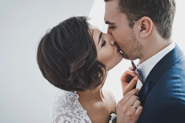 O jovem marido e mulher gentilmente se beijam no backgro — Fotografia de Stock