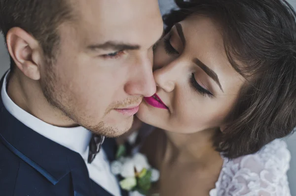 O jovem marido e mulher gentilmente se beijam no backgro — Fotografia de Stock