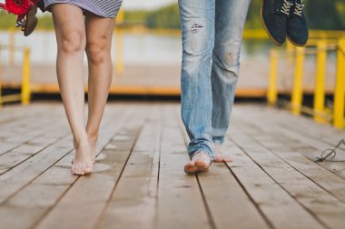 Göl pier yaya köprüsü üzerinde çıplak erkek ve kadın ayak vardır