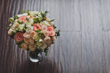 Pembe gülleri ve yeşilliği olan zarif bir düğün buketi..