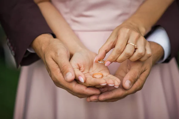 花嫁と新郎の手のひらに金の結婚指輪 — ストック写真