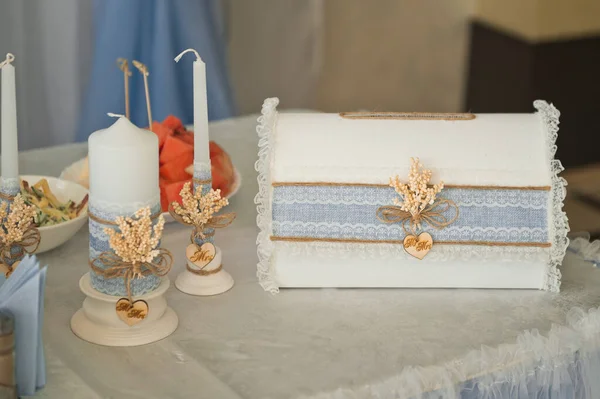 一张桌子 上面有装钱和蜡烛的结婚盒 蓝色的 — 图库照片