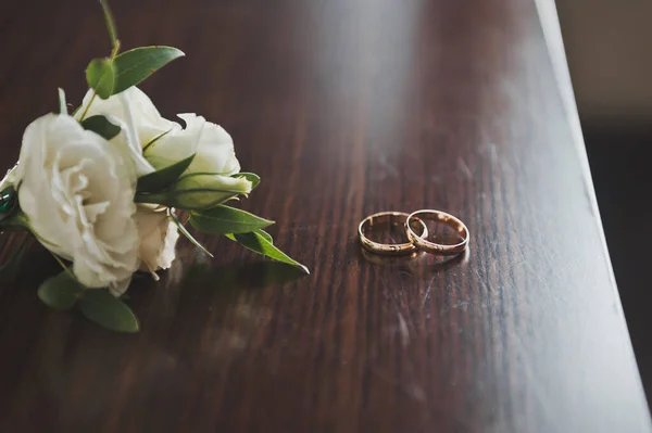 暗いカウンターの上には 花と結婚指輪があります — ストック写真