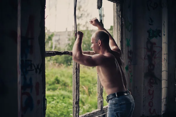 El hombre en ruinas de la casa mira por la ventana 3480 . —  Fotos de Stock