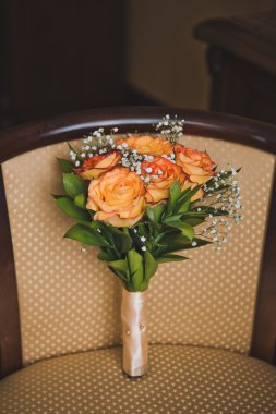 Bir buket çiçek bej bir sandalyeye 3505 yatıyor..