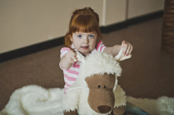 Fiery little girl playing with a toy wolf 4377. — Stock Photo, Image