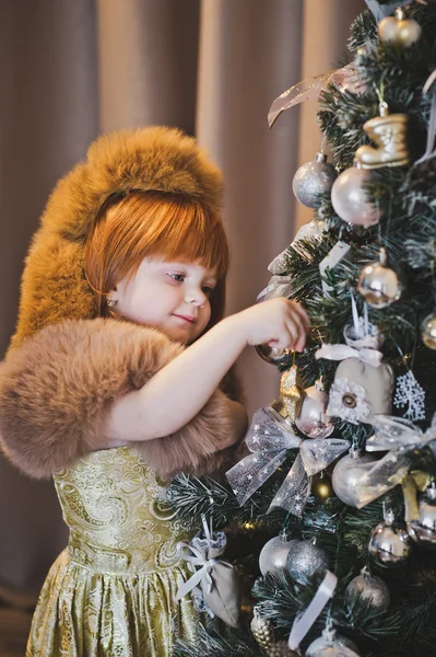 赤い髪の少女がハング 4550 のクリスマスのおもちゃ. — ストック写真