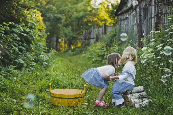 Mädchen und Junge spielen draußen mit Seifenblasen 4745. — Stockfoto