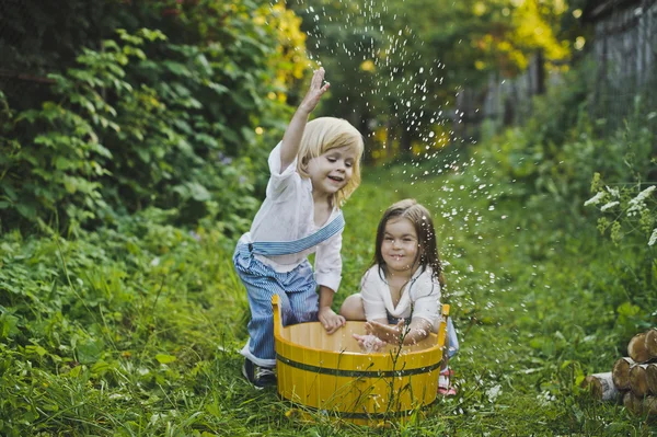 Kinder spielen mit Wasser im Garten 4752. — Stockfoto