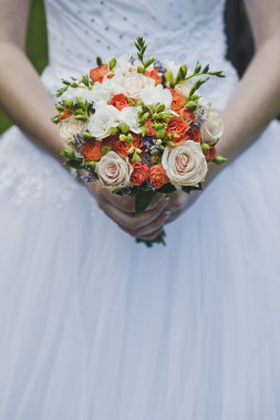 Turuncu ve pembe çiçekler 4 gelinin elinde bir buket