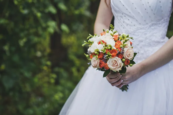 Een boeket van Oranje en roze bloemen in de handen van de bruid 4 — Stockfoto