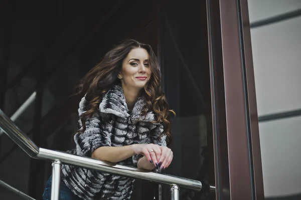 Portrait d'une fille en vêtements d'hiver devant le bâtiment 4995 . — Photo