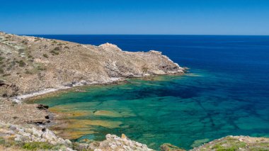 Önünde kayalar olan berrak mavi okyanus.