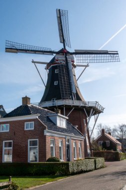 Bulutlu gökyüzünün altında geleneksel Hollanda yel değirmeni