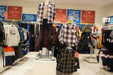 Renkli çocuk bluzları ve mağazadaki kumaş askılarda asılı tişört manzarası. Güzel kız ve erkek bebek çeşitleri süpermarkette stantlar ve askılar üzerinde giyinir. : Dubai BAE - Kasım 2020