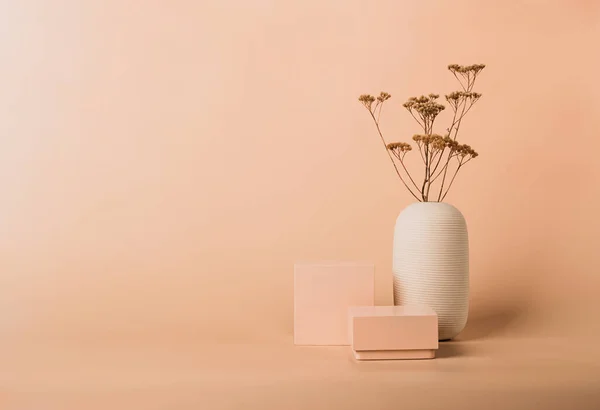 Modern soyut geometrik şekilli podyum pastel arka planda kurumuş çiçekler
