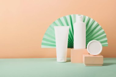 Kozmetik tüpleri şişeler beyaz modern soyut podyumda pastel arka planda