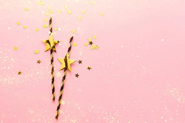 Błyszczące słomki papierowe ze złotymi gwiazdkami pastelowe różowe tło. Przestrzeń kopiowania — Zdjęcie stockowe