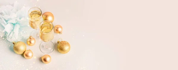 Шампанське в скляних горщиках Золоті кульки Серпантин пастельний рожевий фон — стокове фото