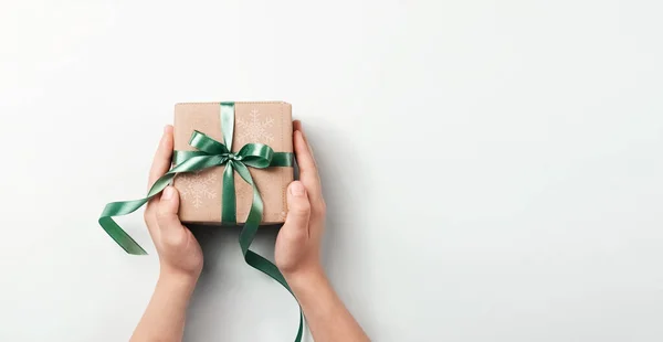 Cadeaudoosje in een prachtige feestelijke papieren verpakking in handen blauwe achtergrond — Stockfoto