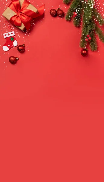 Kırmızı fiyonklu hediye kutuları kırmızı konfeti arka planında Noel oyuncakları