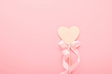 Pembe arka planda doğal malzeme fotoğraf malzemelerinden yapılmış bir kalp. Sevgililer Günü