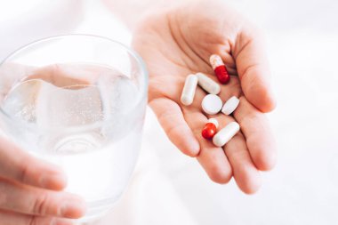 Tıbbi haplar kadınların elinde yatıyor. Sağlık ve ilaç. Seçici odak