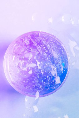 Kozmetik sıvı jel serumu kayganlaştırıcı, oksijen kabarcıklı, mor neon arka planlı hyaluronik asit. Saç, vücut ya da yüz bakımı