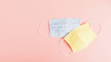 Pembe arka planda çevre dostu yeniden kullanılabilir kumaş güvenlik maskesi. Ev yapımı nefes maskesi, korona virüsüne karşı koruma.