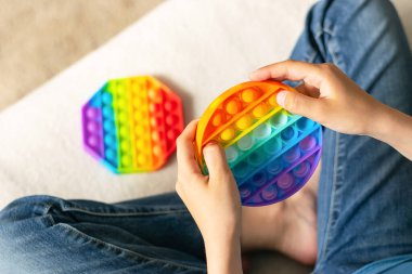 Çocukların elleri, modaya uygun bir anti-stres oyuncağı oynar. Çocuk yumuşak baloncuklu silikon bir oyuncakla oynuyor.