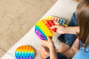 Çocukların elleri, modaya uygun bir anti-stres oyuncağı oynar. Çocuk yumuşak baloncuklu silikon bir oyuncakla oynuyor.