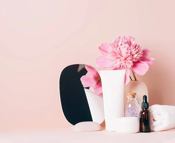 Los accesorios para mujer el espejo el aceite de la crema los cosméticos distintos sobre la mesa con las flores. Cuidado corporal y facial concepto de belleza de salud — Foto de Stock