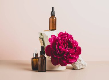 Cam damlası podyumunu pastel arka planı, çiçekleri ve taşları, soyut arka planı olan modayla süslemek 