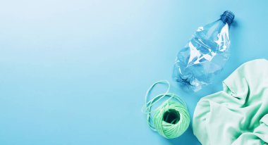 Plastiği geri dönüşüm konsepti. Boş plastik şişe ve geri dönüştürülmüş polyester iplik, sentetik kumaş mavi arkaplan