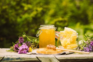 Kırsal alanda cam bir kavanozda taze bal. Çiçek kokulu tatlı tatlı tatlı, ön manzara 