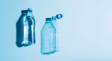 Su dolu plastik şişeler ve kullanılmış mavi arka plan. Geri dönüşümlü plastik. Çevre koruma