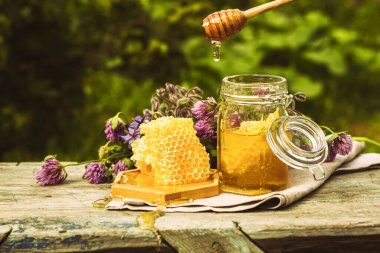 Kırsal alanda cam bir kavanozda taze bal. Çiçek kokulu tatlı tatlı tatlı, ön manzara 