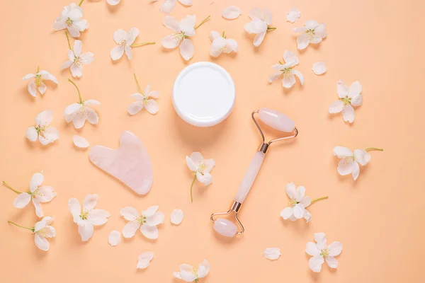 Set de masaje facial rascador de rodillos guasha cuidado facial de suero de aceite cosmético sobre fondo rosa pastel — Foto de Stock