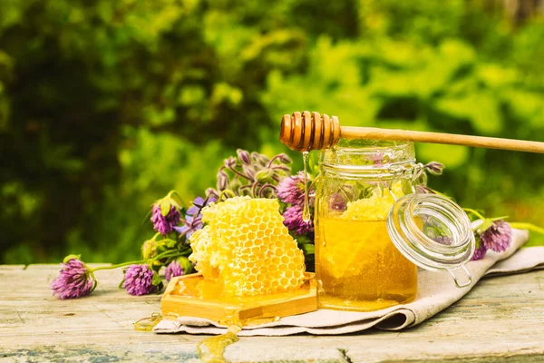 Fresh honey in a glass jar on a summer rural background. Floral fragrant sweet honey dessert, front view — Stock Photo, Image