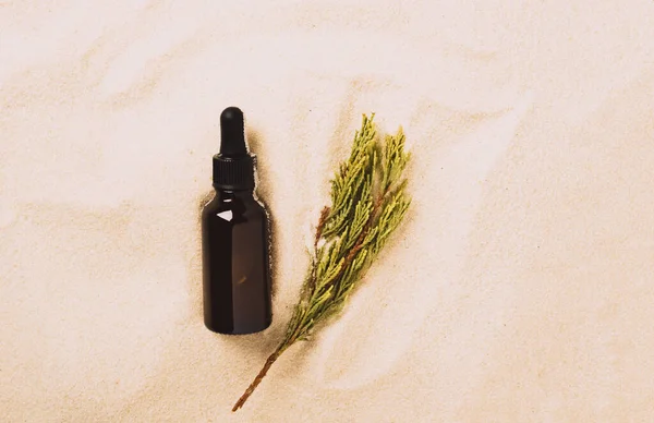 Bottle of serum oil cosmetic product beach sand background. Abstract podium product presentation on a sandy background — Stock Photo, Image