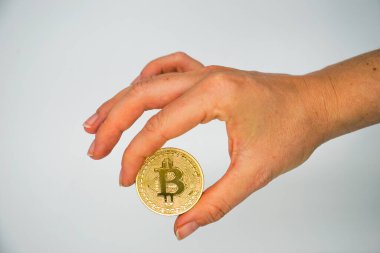 İki parmak arasındaki altın bitcoin - kripto para birimi için kavramsal resim - Gelecek para birimi - beyaz arkaplan