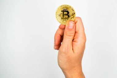 Bitcoin: The new virtual money / Close Up shot of Hand holdling one golden Bitcoin: Business, Money and Technology Concept 